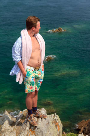 Beautiful view of a colorful young tourist on the rocks at Pointe du Grouin near Cancale in Brittany, France,  in summerの写真素材