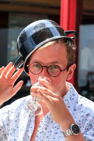 Colorful young tourist drank a white wine to much with his mussels in the hot summer sun in Cancale, Franceの写真素材