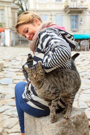 Beautiful tourist in the Old Town of the city of Plovdiv, Bulgaria, with a catの写真素材