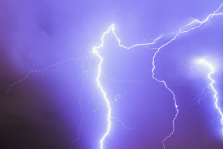 Beautiful purple lightning flashes during a thunderstorm at night in Amsterdam, the Netherlands