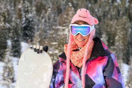 Beautiful portrait of a young woman with pig hat  and goggles on a sunny day in the Alps in the Brandnertal, Vorarlberg Austriaの写真素材