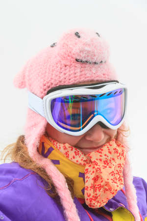 Beautiful portrait of a young woman with pig hat  and goggles on a cold winter day in the Alps in the Brandnertal, Vorarlberg Austriaの写真素材