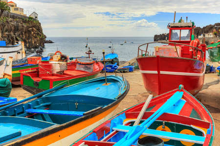 Beautiful view of the colored fisher boats in the Harbor of Camara de Lobos on the island of Madeira in summerの写真素材