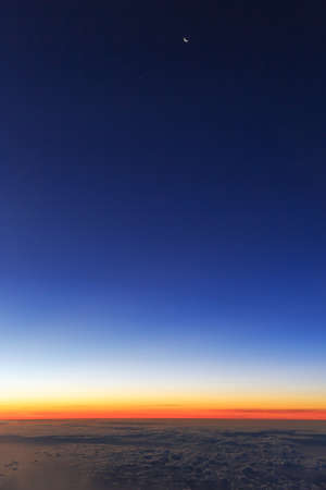 Beautiful aerial sunrise cloudscape with a new moon in the morning sky in the Netherlandsの写真素材