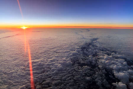 Beautiful aerial sunrise cloudscape with a blue morning sky and bright summer sun in the Netherlandsの写真素材