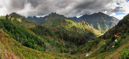 Beautiful 180 degree panoramic landscape panorama of the mountains of Madeira on a cloudy summer dayの写真素材
