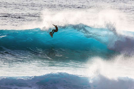 Surfer riding the big blue surf waves on the island Madeira, Portugal, a popular surfing tourist destination on October 8, 2015のeditorial素材