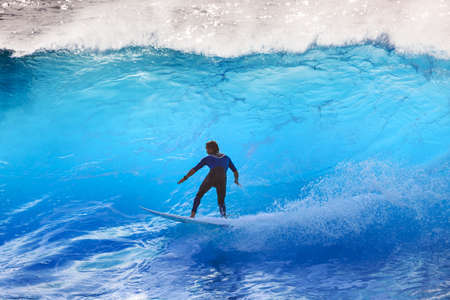 Surfer riding the big blue surf waves on the island Madeira, Portugal, a popular surfing tourist destination on October 8, 2015のeditorial素材