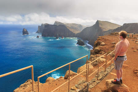 Tourist on the cliffs in the beautiful landscape of the east coast of Madeira at Ponta de Sao Lourenco nature reserveの写真素材