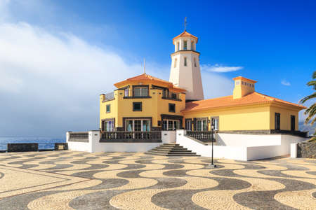 Beautiful lighthouse on the east coast of Madeira island, near Canical, with traditional pavement and blue sky in summerの写真素材