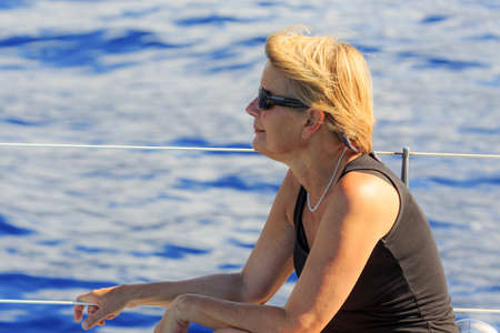 Senior tourist enjoys a whale and dolphin watching catamaran excursion from Funchal, on the island of Madeira in summerの写真素材
