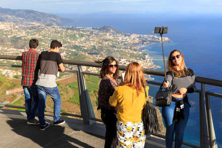 Tourists make selfies at the Cabo Girao glass platform, a viewpoint on top of the big cliffs of the island Madeira, on October 11, 2015のeditorial素材