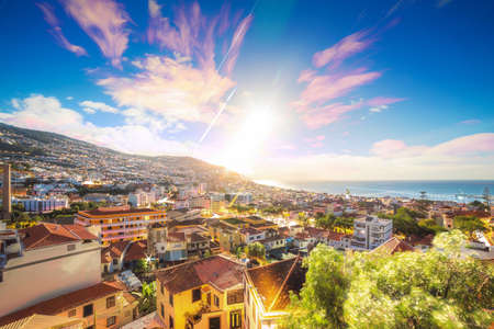 Beautiful long exposure stacked view of the skyline cityscape of the city Funchal on the island Madeira at sunrise in summer with startrailsの写真素材