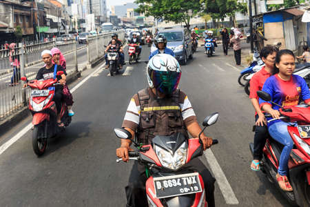 Typical view of people commuting with scooter in traffic in the streets of Jakarta, Indonesia, on August 2, 2015のeditorial素材