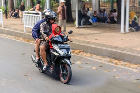 Typical view of people commuting with scooter in traffic in the streets of Jakarta, Indonesia, on August 2, 2015のeditorial素材