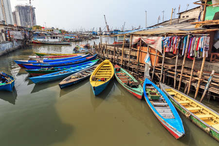 Beautiful view of generic homes with canoes on the waterfront in the old Sunda Kelapa harbor area in Jakarta, Indonesiaの写真素材
