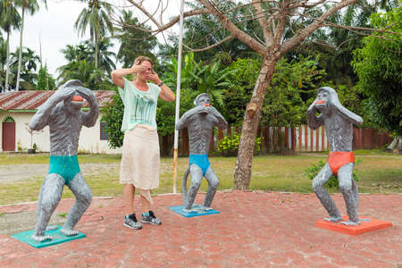 Three wise monkeys (see no evil, hear no evil, speak no evil) and a beautiful woman at a Hindu temple in Sumatra, Indonesiaの写真素材