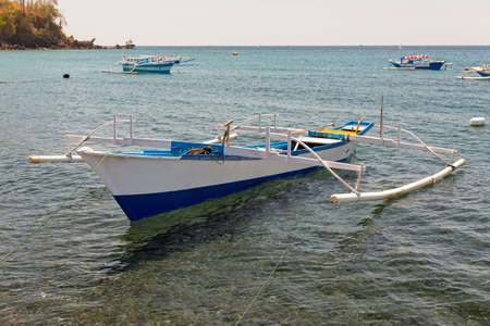 Beautiful view of traditional fishing boat (outrigger canoe aka lipa-lipa or jukung) on the island of North Sulawesi, Indonesiaの写真素材