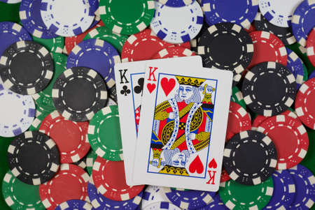 poker, hand - pocket kings clubs and hearts on colorful chipsのeditorial素材