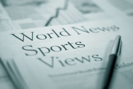 newspaper pages `world news` `sports` `views` with a penの写真素材