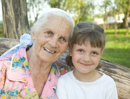 portrait of smiling great-grandmother and her granddoughter
