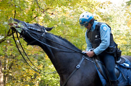 MONTREAL, CANADA - SEPTEMBER, 2015 - Montreal policeman on horse giving a ticket.のeditorial素材