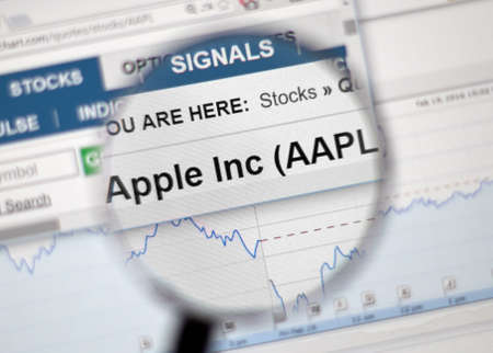 MONTREAL, CANADA - FEBRUARY, 2016 - AAPL - Apple Inc stock ticker with charts under magnifying glass.のeditorial素材