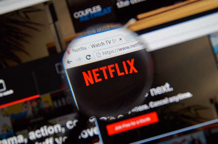 MONTREAL, CANADA - FEBRUARY, 2016 - Netflix - popular movie portal under magnifying glass.のeditorial素材