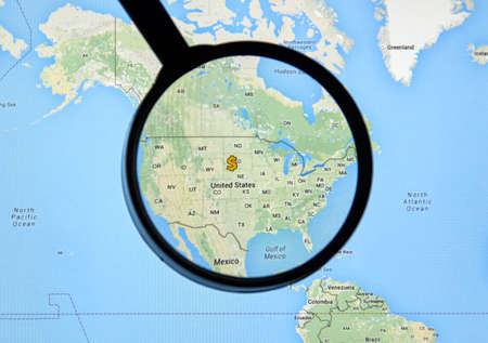 MONTREAL, CANADA - FEBRUARY, 2016 - USA with dollar sign on Google Maps under magnifying glass.のeditorial素材