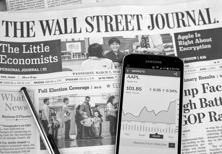 MONTREAL, CANADA - MARCH 3, 2016 - The Wall Street Journal Newspaper with Samsung S5 on it. The Wall Street Journal Is an American international daily newspaper.のeditorial素材