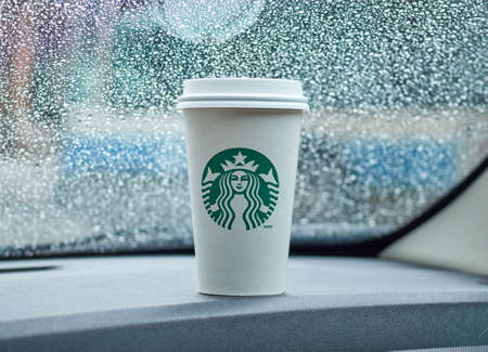MONTREAL, CANADA - MARCH 16, 2016 - Starbucks coffee cup in a car on a raining day. Starbucks is one of the popular American coffee company and coffeehouse chain.のeditorial素材
