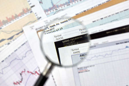 MONTREAL, CANADA - JANUARY 20, 2017 : Alphabet Google stock exchange ticker under magnifying glass on candlestick background.のeditorial素材
