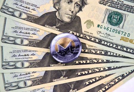MONTREAL, CANADA - MARCH 10, 2018: Monero cryptocurrency coin and logo on american dollar bank notes.のeditorial素材