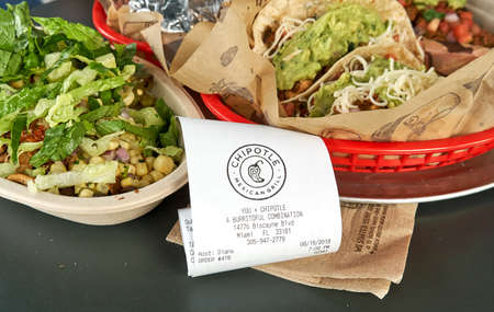 MIAMI, USA - AUGUST 22, 2018: Chipotle plate and receipt. Chipotle restaurant logo. Chipotle Mexican Grill is an American chain of fast casual restaurantsのeditorial素材