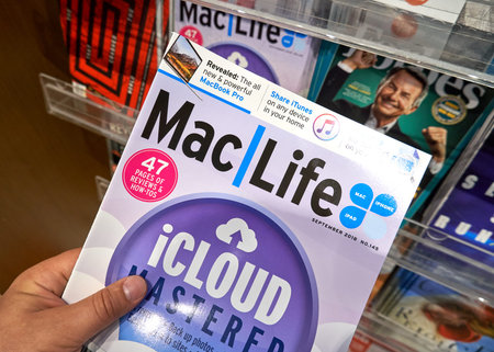 MIAMI, USA - AUGUST 22, 2018: MacLife magazine in a hand over a stack of magazines. MacLife is a...
