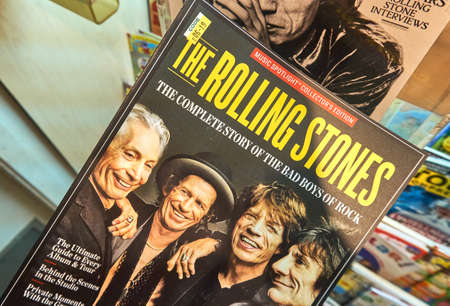 MONTREAL, CANADA - JULY 9, 2018: Rolling Stone magazine in a hand over a stack of magazines. Rolling Stone is an American magazine which focuses on popular culture.のeditorial素材