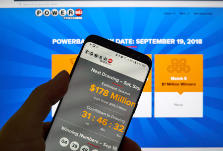 MONTREAL, CANADA - SEPTEMBER 23, 2018: Powerball page on a cellphone screen over a laptop screen....