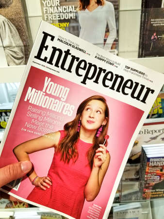 TORONTO, CANADA - DECEMBER 9, 2018: Entrepreneur magazine in a hand over a stack of magazines. Entrepreneur is an American magazine that carries news stories about entrepreneurshipのeditorial素材