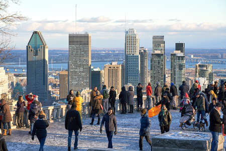 MONTREAL, CANADA - JANUARY 1, 2019 : Scenic view of downtown Montreal in winter from Mount Royal Chalet, and people taking pictures and making selfies.のeditorial素材