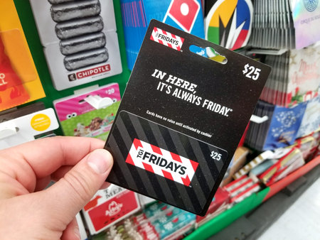 PLATTSBURGH, USA - JANUARY 21, 2019 : TGI Fridays gift card in a hand over a shelves with different...