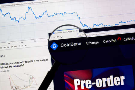 MONTREAL, CANADA - APRIL 26, 2019: Coinbene cryptocurrency digital assets exchange logo and home page on a laptop screen under magnifying glass.のeditorial素材