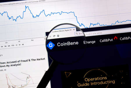 MONTREAL, CANADA - APRIL 26, 2019: Coinbene cryptocurrency digital assets exchange logo and home page on a laptop screen under magnifying glass.のeditorial素材