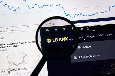 MONTREAL, CANADA - APRIL 26, 2019: Lbank.info cryptocurrency digital assets exchange logo and home page on a laptop screen under magnifying glass.のeditorial素材