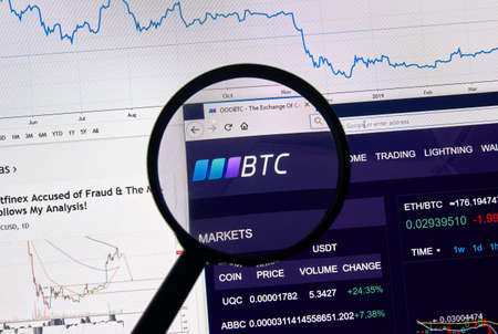 MONTREAL, CANADA - APRIL 26, 2019: OOOBTC cryptocurrency digital assets exchange logo and home page on a laptop screen under magnifying glass.のeditorial素材