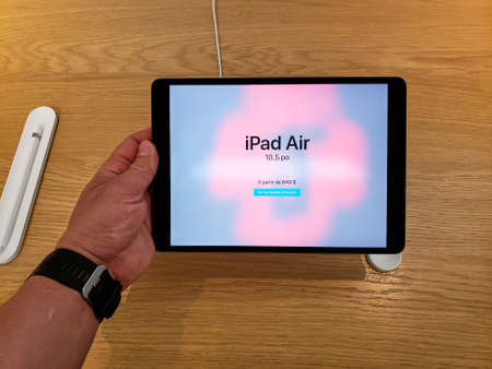 MONTREAL, CANADA - JUNE 20, 2019: Apple iPad Air in a hand at Apple store. Apple Inc. is an American multinational technology company headquartered in California, USA.のeditorial素材