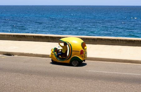 Havana, Cuba - May 08, 2019: Yellow taxi on Havana street in Cuba. Taxi is one of the methods of...