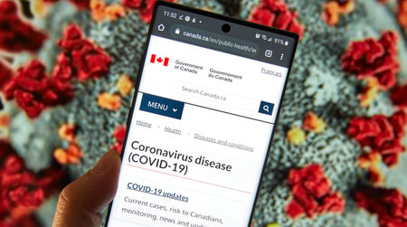Montreal, Canada - March 21, 2020: Coronavirus updates and statistics in Canada on government site on mobile screen. COVID-19 is a novel coronavirusのeditorial素材