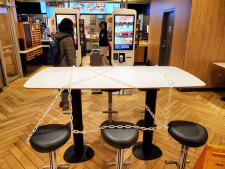 Montreal, Canada - March 22, 2020: Chained seats and tables in McDonalds due to coronavirus. Many restaurants and fast food places put chain on tables and seats to prevent people sittingのeditorial素材