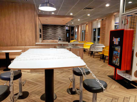 Montreal, Canada - March 22, 2020: Chained seats and tables in McDonalds due to coronavirus. Many restaurants and fast food places put chain on tables and seats to prevent people sittingのeditorial素材