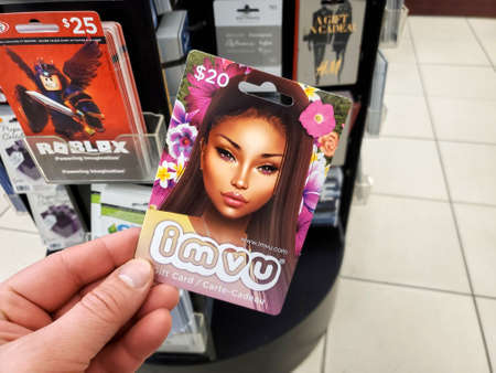 Montreal, Canada - March 22, 2020: IMVU gift card in a hand over gift cards background. IMVU is an avatar based online metaverse and social game.のeditorial素材